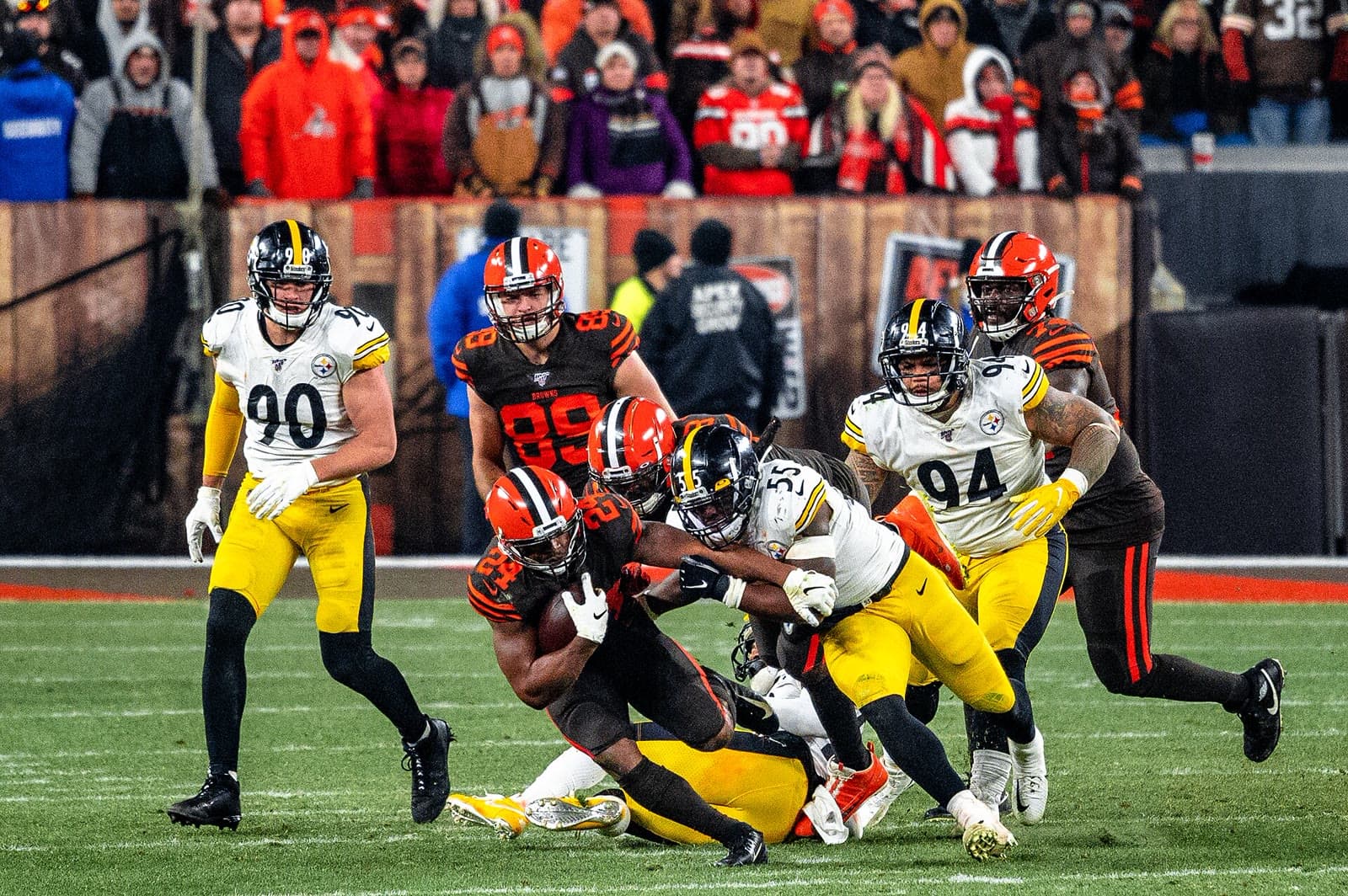 Steelers defenders, T.J. Watt among them in No. 90, close on a Browns ball carrier in Cleveland.